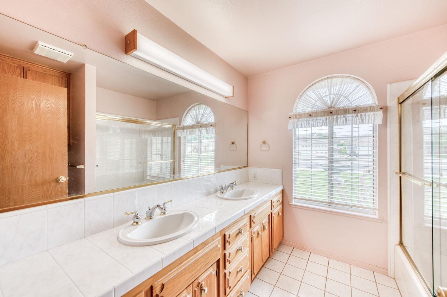 2530 Sterling Avenue Sanger, CA 93657 - Photo 32 of 40 a bathroom with a granite countertop sink mirror and a large window