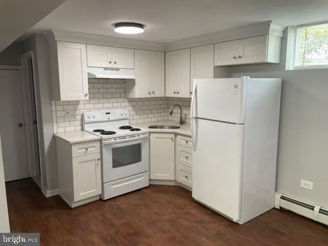 a kitchen with white cabinets and white appliances