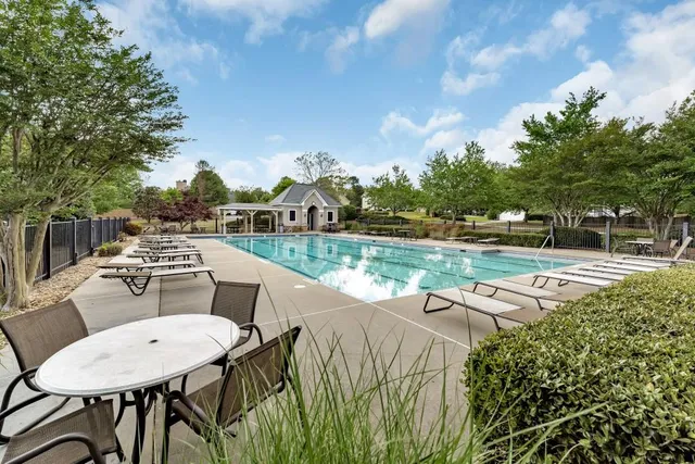 a view of a patio with table and chairs a barbeque with potted plants and big trees