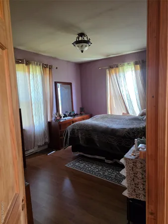 a kitchen with stainless steel appliances kitchen island granite countertop a table chairs in it and a wooden floor