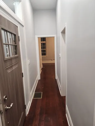 a view of a hallway with wooden floor and entryway