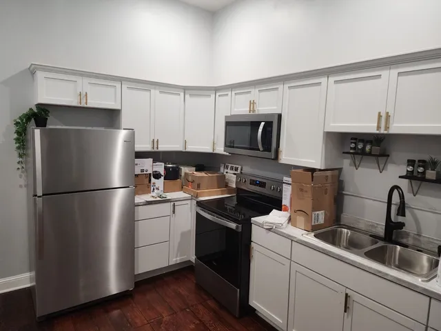 a kitchen with a refrigerator sink and white cabinets