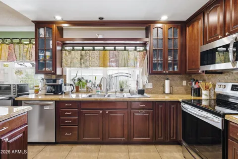 a kitchen with stainless steel appliances granite countertop a refrigerator a sink a stove and island