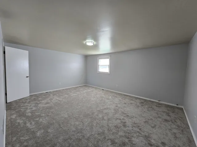 an empty room with windows and closet in it