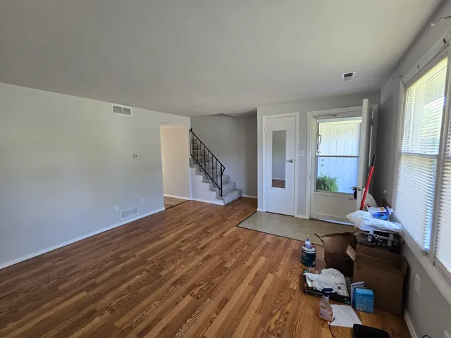 a view of a livingroom with wooden floor and a window
