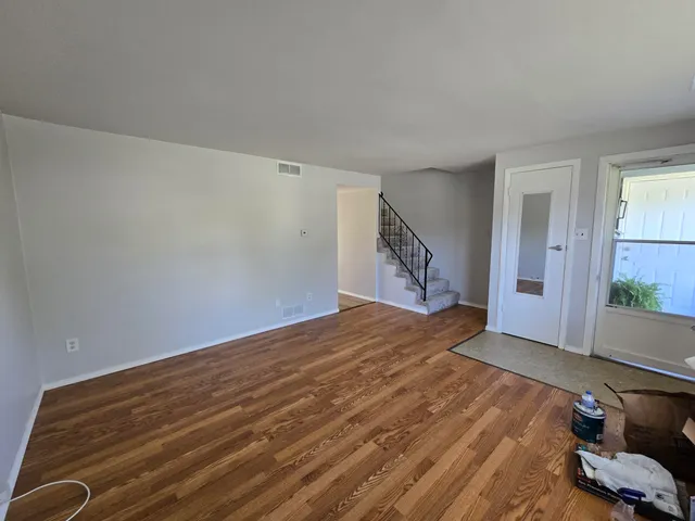 a view of empty room with wooden floor