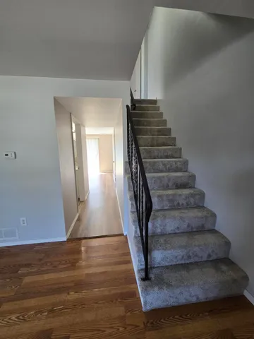 a view of entryway and hall with wooden floor