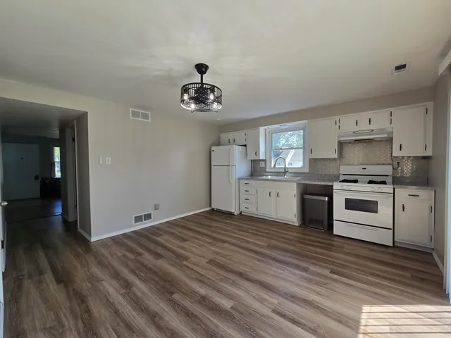 a kitchen with a stove and white cabinets