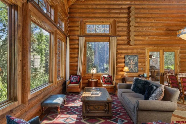 a living room with furniture and floor to ceiling windows