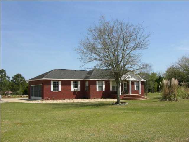 5865 Bush Road Baker, FL 32531 - Photo 1 of 32 a front view of a house with a garden