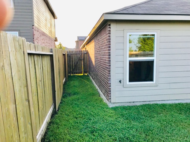20105 Grover Cleveland Way Manor, TX 78653 - Photo 16 of 17 A well-maintained side yard with secure fencing ensures privacy and access.