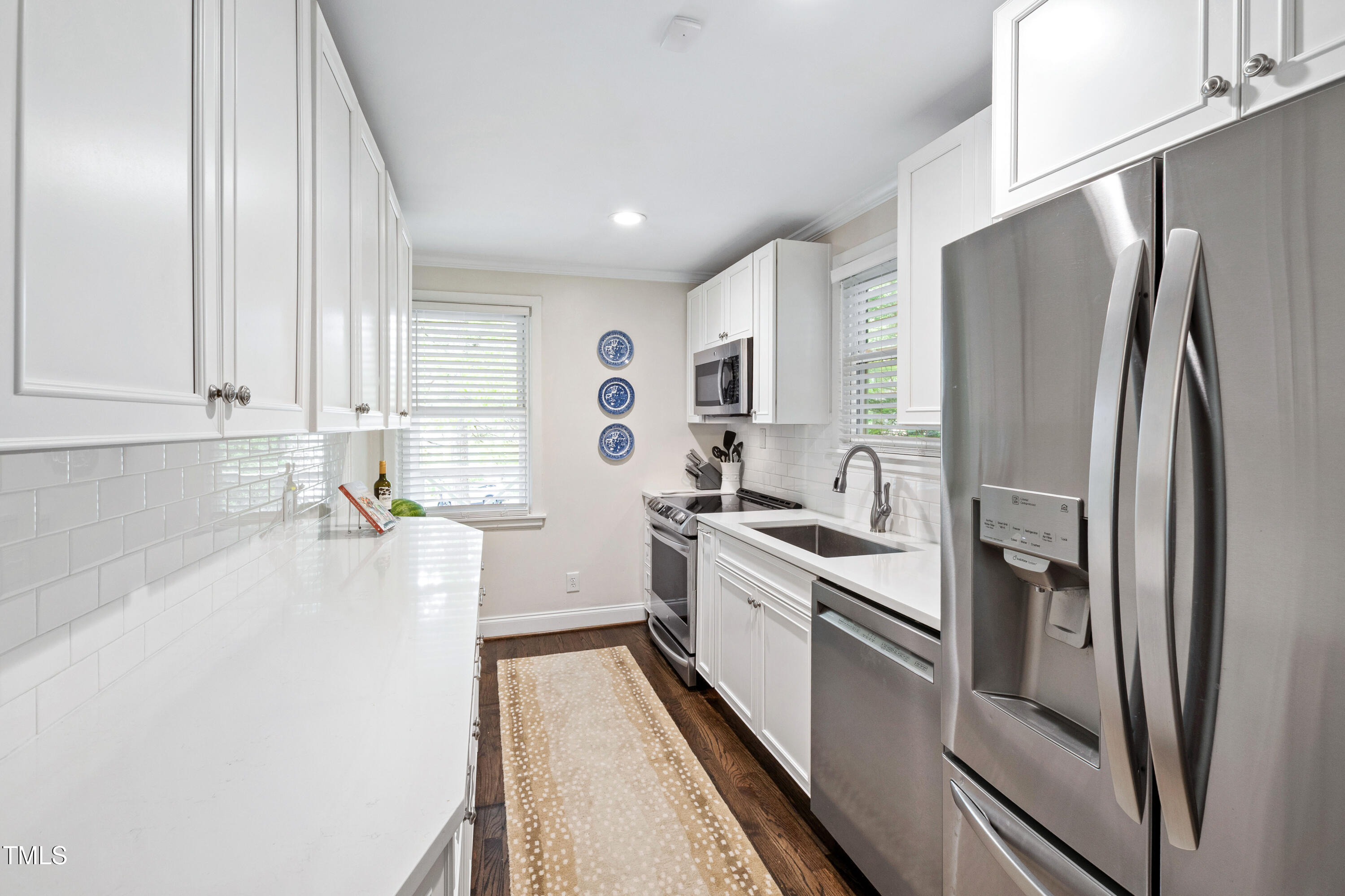 2415 Van Dyke Avenue Raleigh, NC 27607 - Photo 10 of 24 a kitchen with stainless steel appliances a refrigerator sink and white cabinets