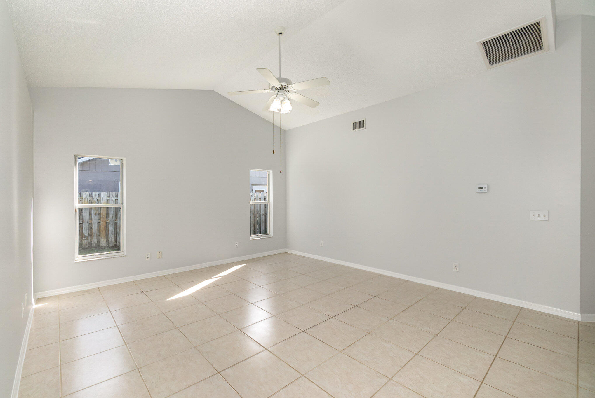 4655 Willow Bend Drive Melbourne, FL 32935 - Photo 12 of 27 an empty room with windows and chandelier fan