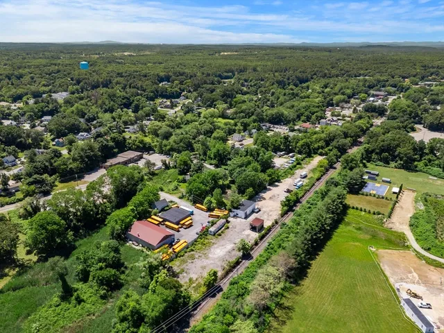 an aerial view of residential houses with outdoor space and trees