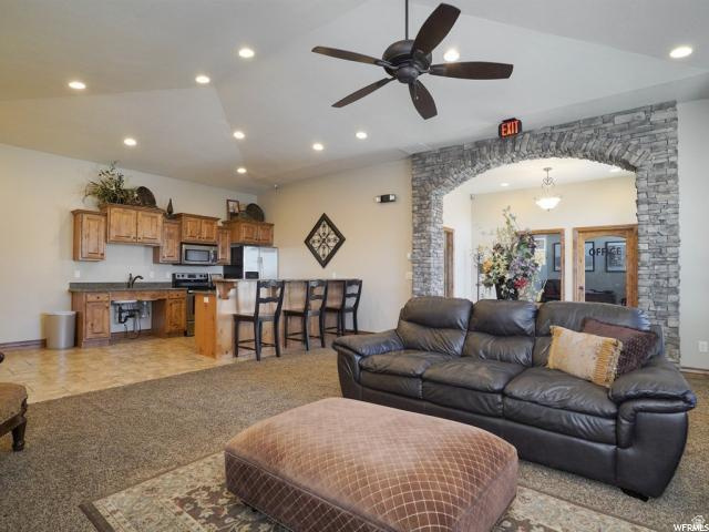 917 South Main Street, Unit H Layton, UT 84041 - Photo 18 of 19 Living area featuring arched walkways, a ceiling fan, light colored carpet, lofted ceiling, and recessed lighting