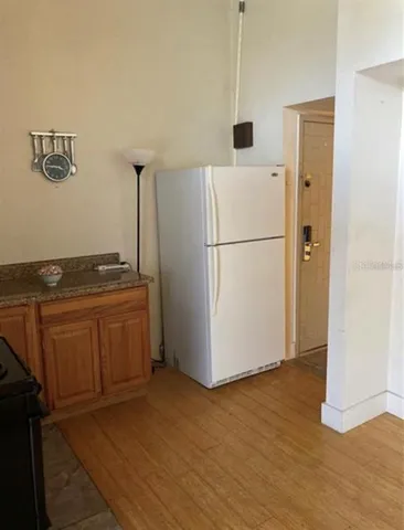 a white refrigerator freezer and a stove sitting inside of a kitchen