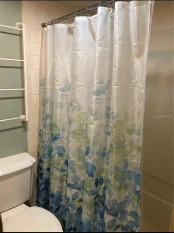 a white toilet sitting next to a shower curtain