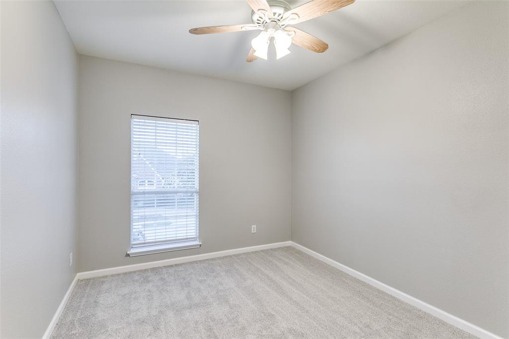 4532 Crown Ridge Drive Plano, TX 75024 - Photo 13 of 25 Carpeted interior space featuring a window with white blinds, a ceiling fan with light fixture, and light gray walls