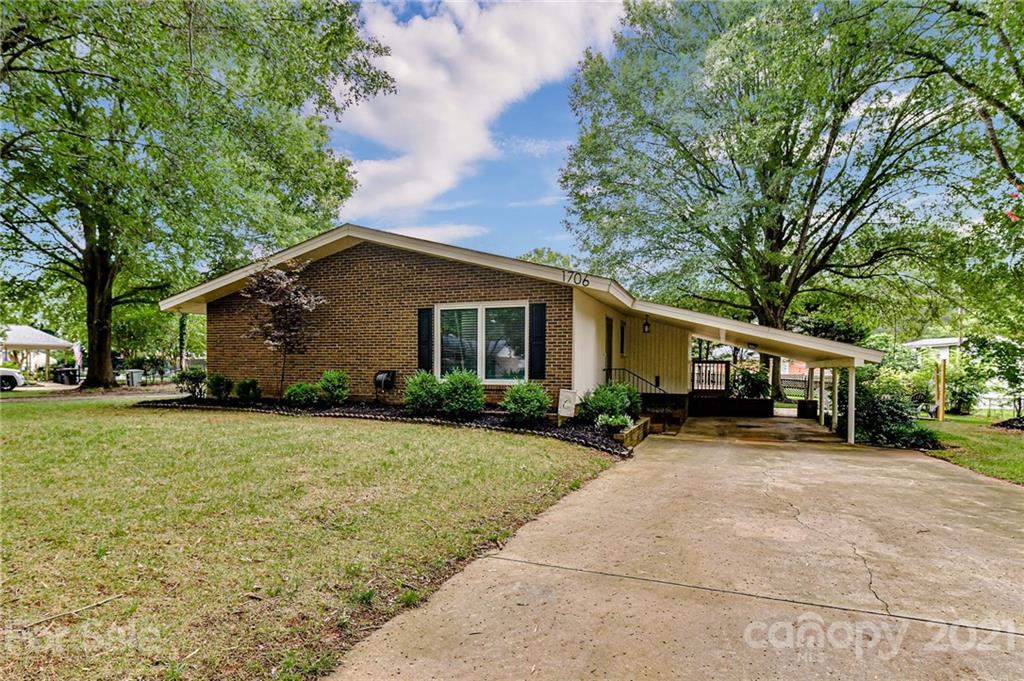 a view of a house with backyard and trees