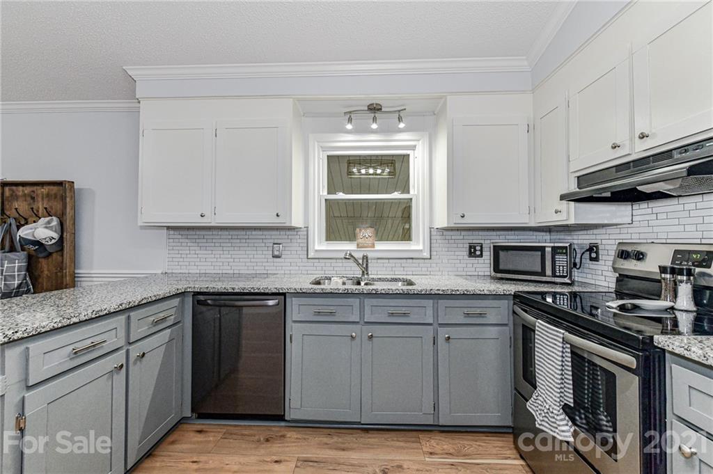 1706 Carson Street Monroe, NC 28110 - Photo 11 of 36 a kitchen with stainless steel appliances granite countertop a sink stove and cabinets