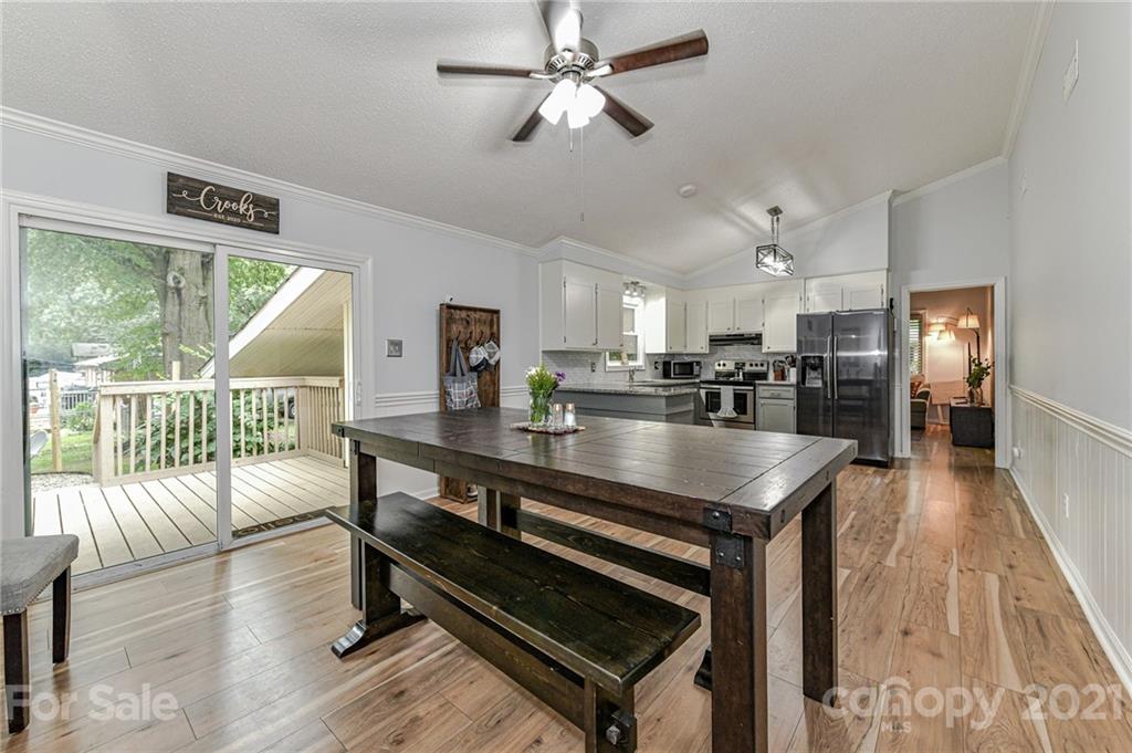 1706 Carson Street Monroe, NC 28110 - Photo 14 of 36 a kitchen with stainless steel appliances kitchen island granite countertop a refrigerator a stove a dining table and chairs with wooden floor