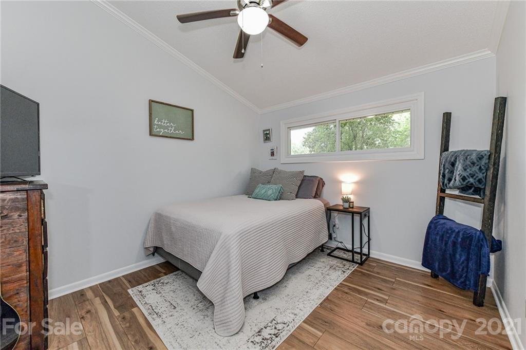 1706 Carson Street Monroe, NC 28110 - Photo 20 of 36 a bedroom with a bed and a chandelier
