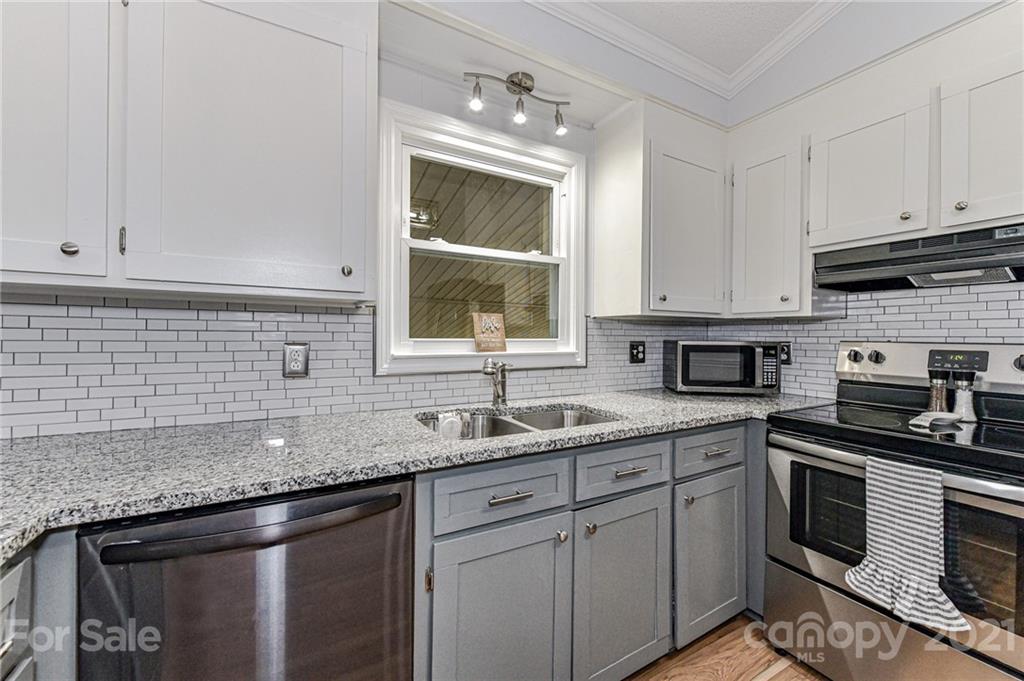 1706 Carson Street Monroe, NC 28110 - Photo 10 of 36 a kitchen with stainless steel appliances granite countertop a sink stove and cabinets