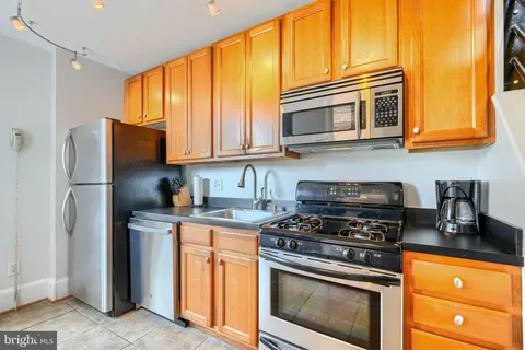 a kitchen with stainless steel appliances granite countertop a sink a refrigerator and a stove