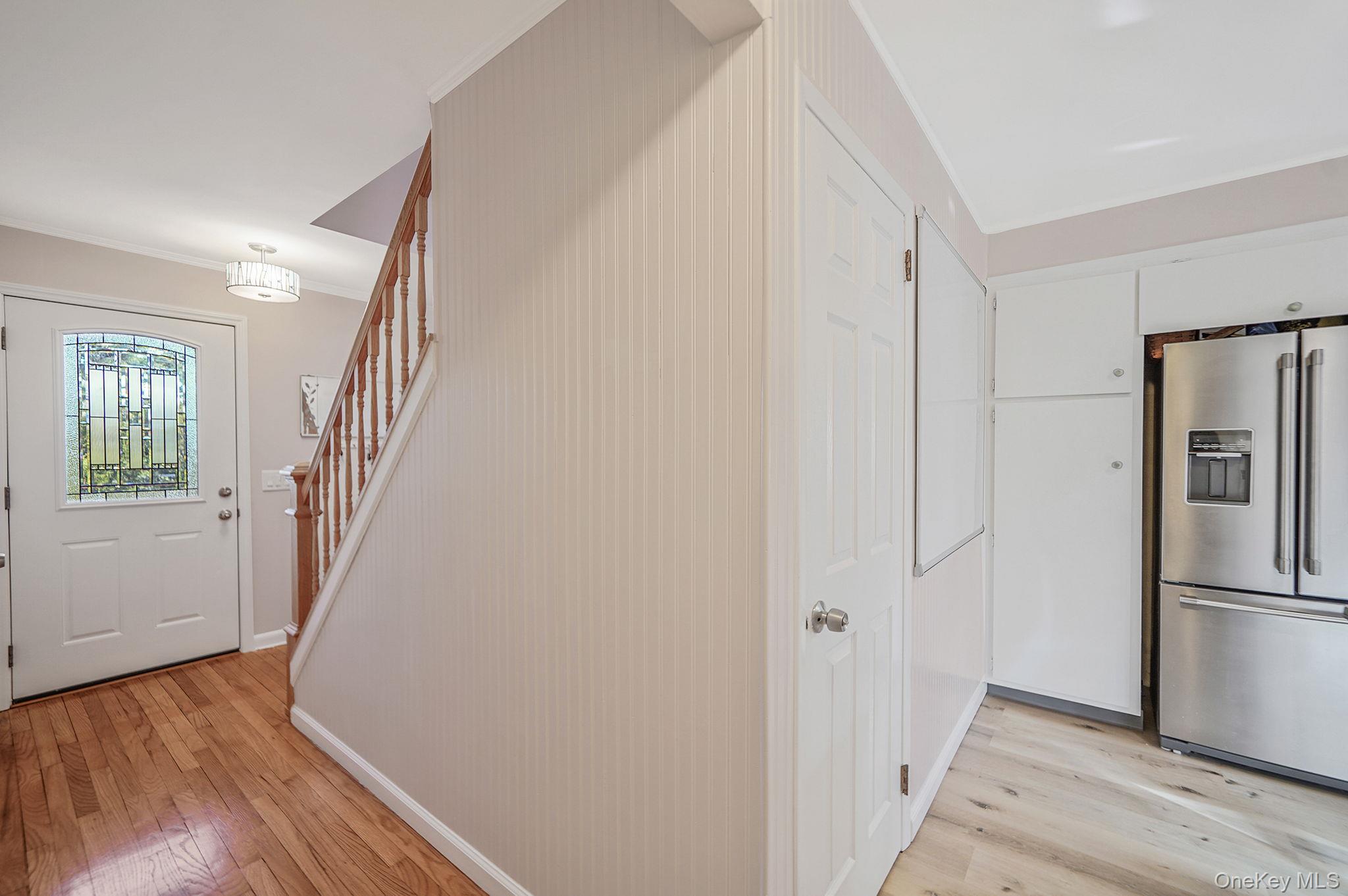 12 Harbor Beach Road Miller Place, NY 11764 - Photo 12 of 45 Entryway featuring stairway, light wood-type flooring, and ornamental molding