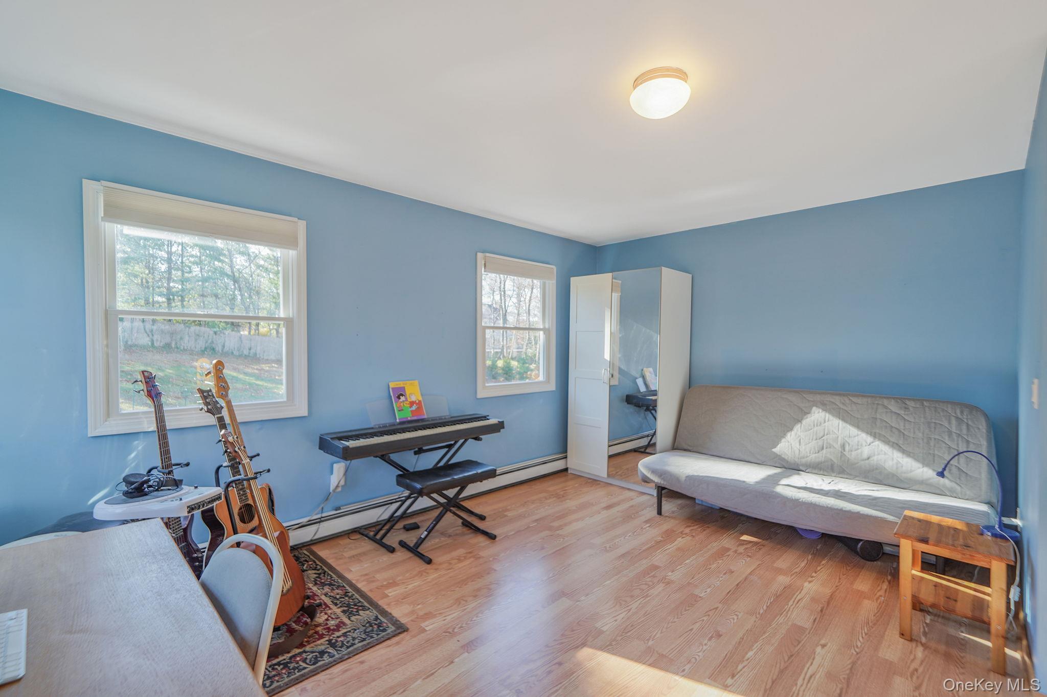 12 Harbor Beach Road Miller Place, NY 11764 - Photo 25 of 45 Living area featuring wood finished floors and a baseboard radiator