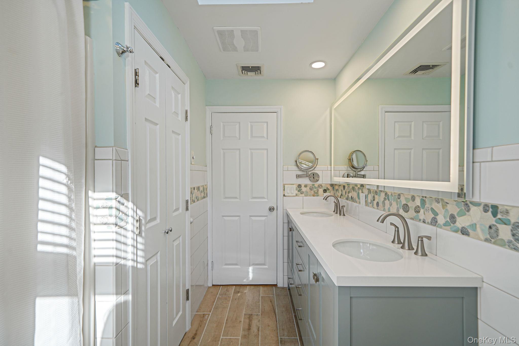 12 Harbor Beach Road Miller Place, NY 11764 - Photo 31 of 45 Bathroom featuring double vanity and wood tiled floors
