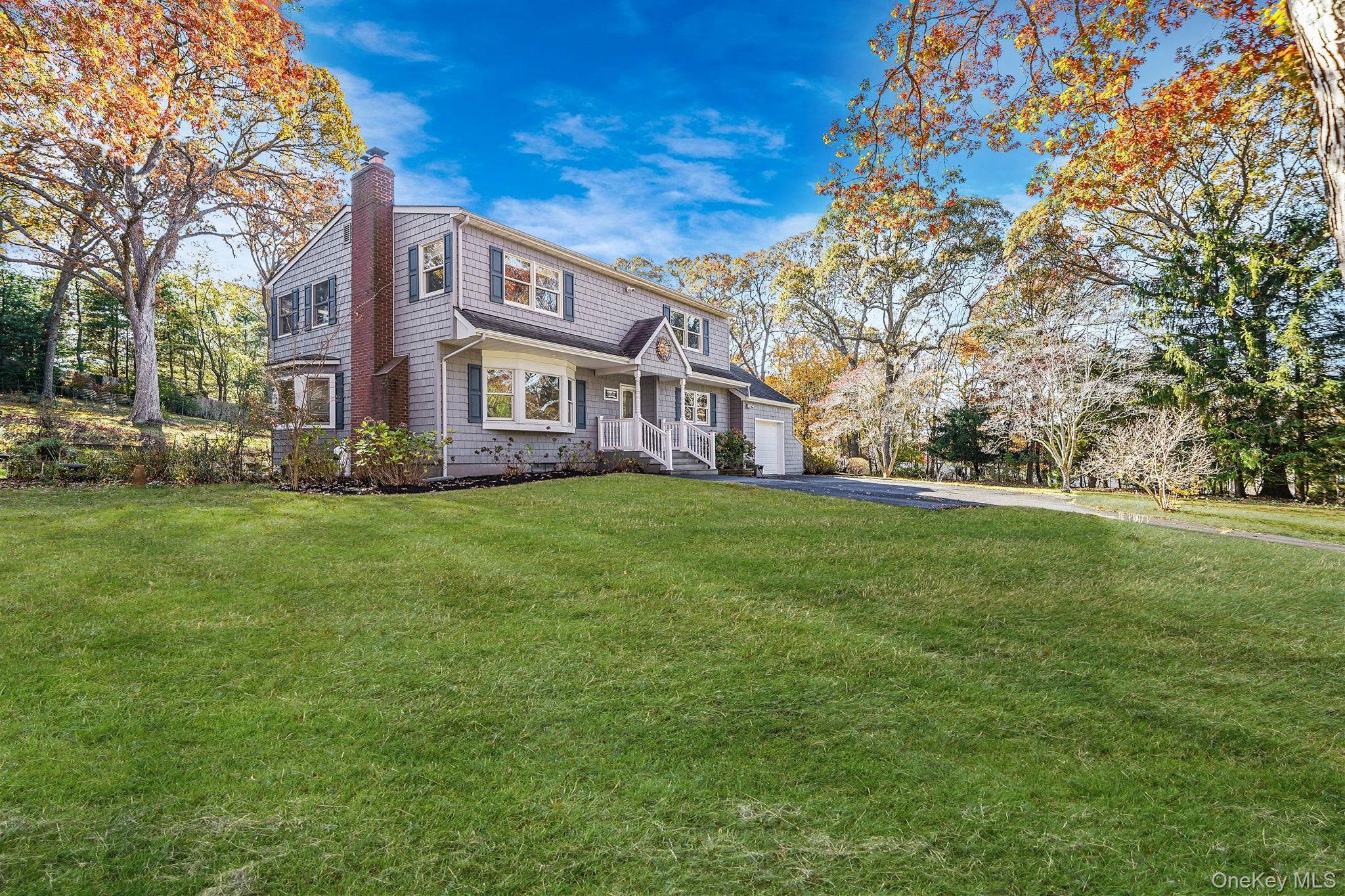 12 Harbor Beach Road Miller Place, NY 11764 - Photo 32 of 45 View of front of house featuring a front yard, a chimney, driveway, and a garage