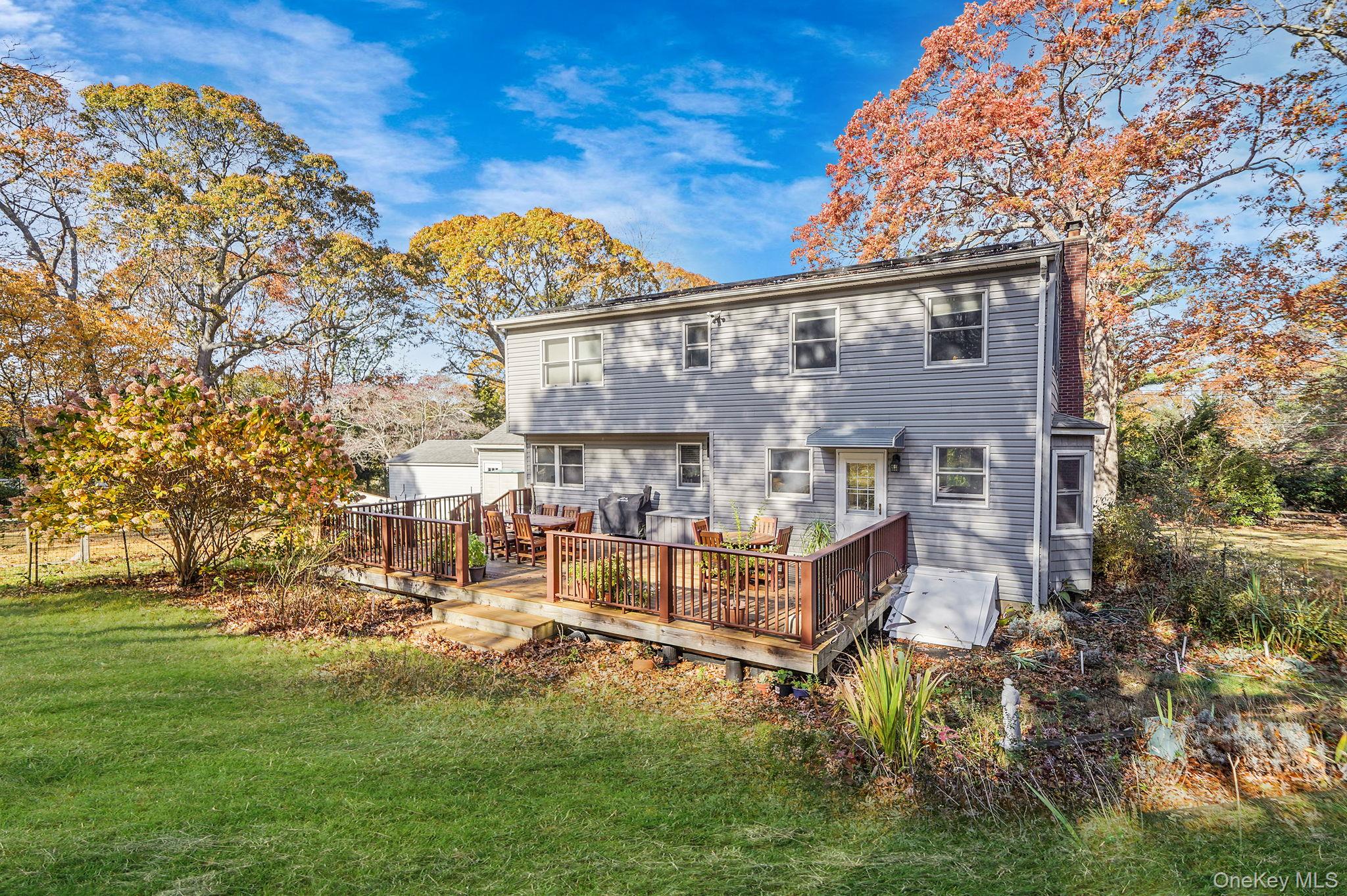12 Harbor Beach Road Miller Place, NY 11764 - Photo 41 of 45 Back of house featuring a chimney, a yard, and a wooden deck