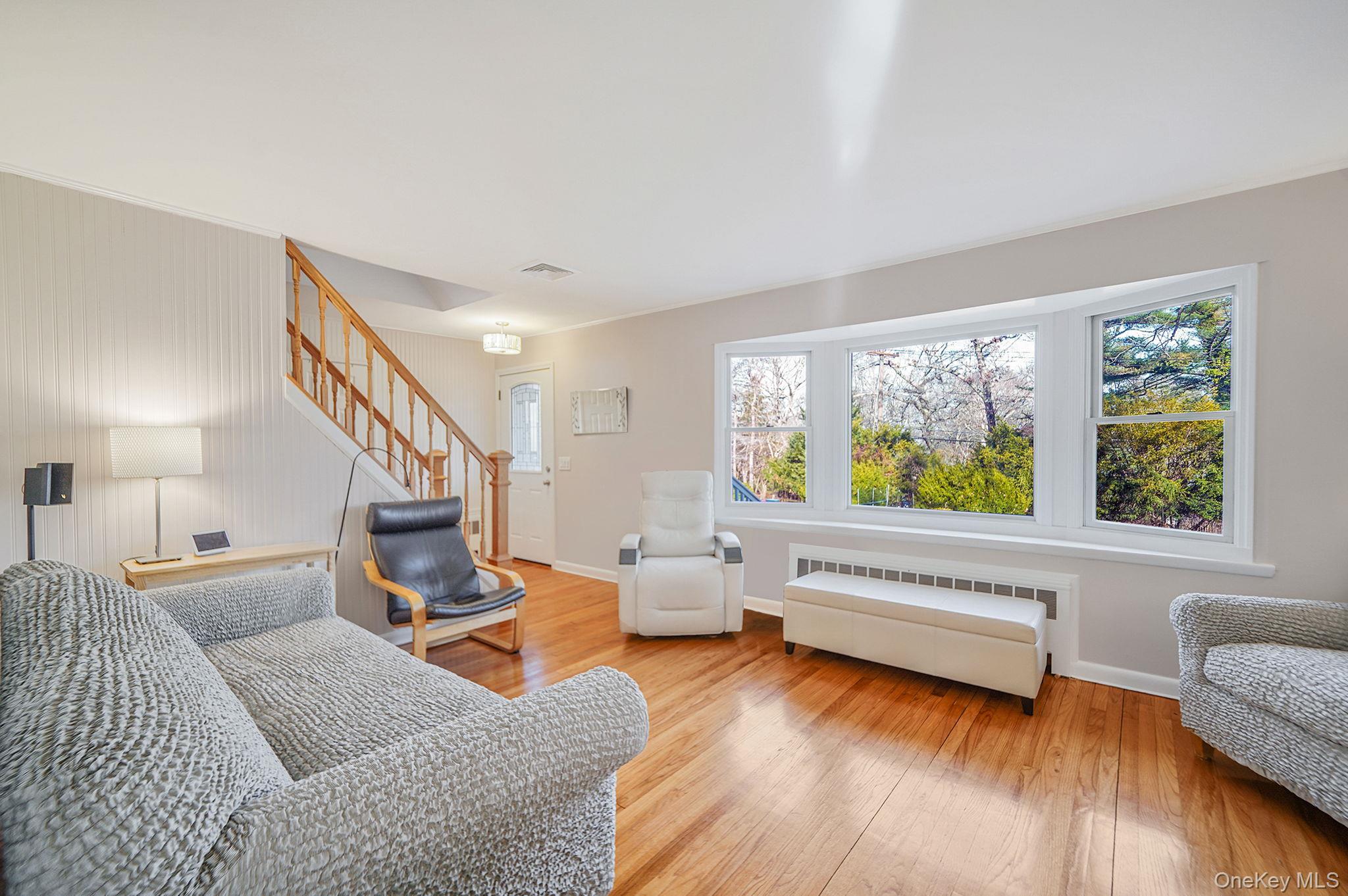 12 Harbor Beach Road Miller Place, NY 11764 - Photo 5 of 45 Living area with light wood-style flooring, stairs, and radiator