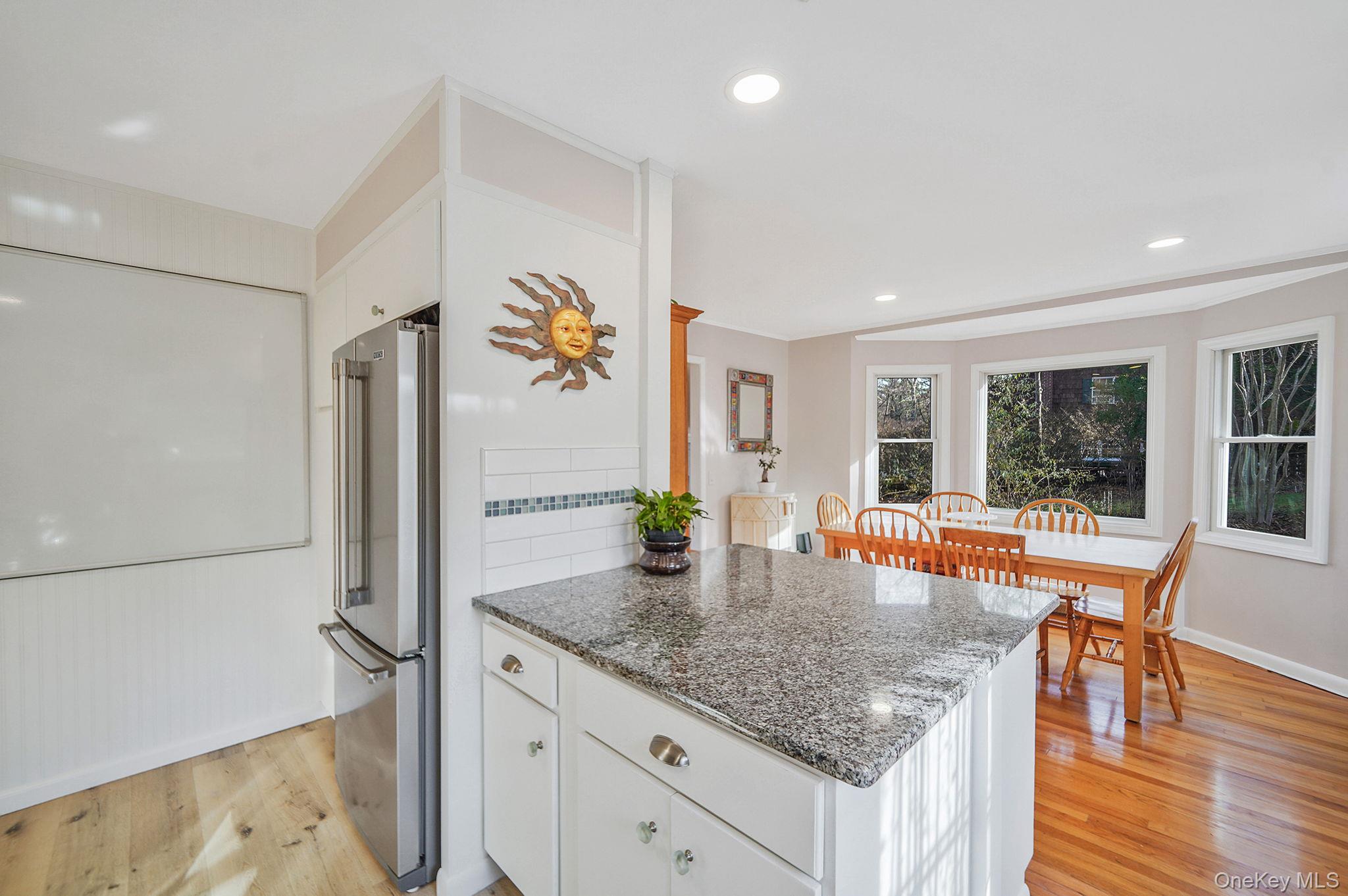 12 Harbor Beach Road Miller Place, NY 11764 - Photo 10 of 45 Kitchen with white cabinetry, dark stone counters, light wood-style floors, high end refrigerator, and a peninsula