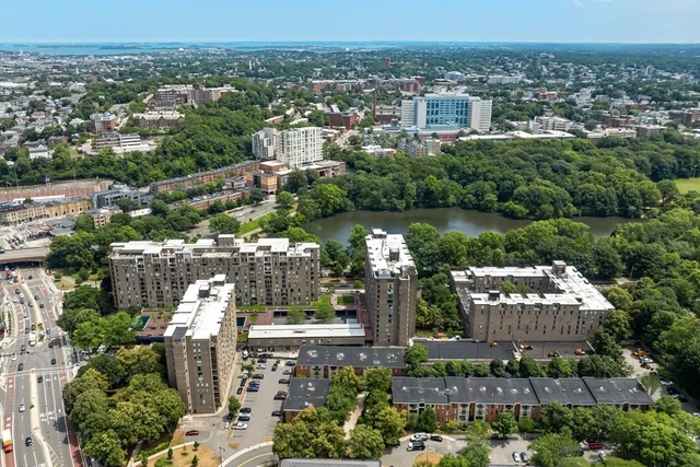 an aerial view of a city with lots of residential buildings and mountain view in back