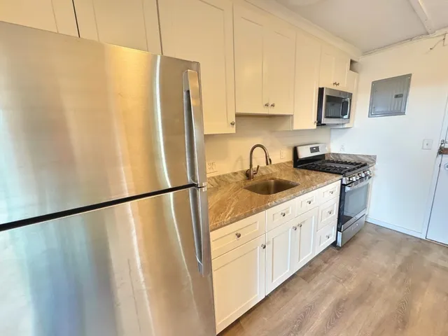 a kitchen with stainless steel appliances a refrigerator a sink a stove a microwave and cabinets