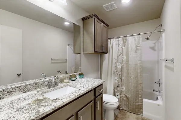 a bathroom with a granite countertop sink toilet and shower