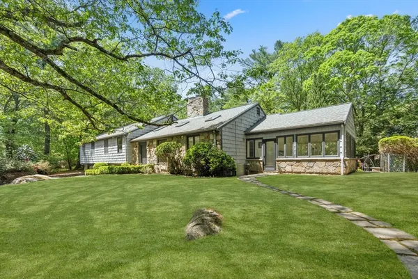 a view of a house with a big yard and large trees