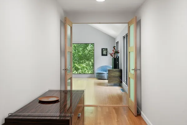 a view of a hallway with wooden floor and furniture