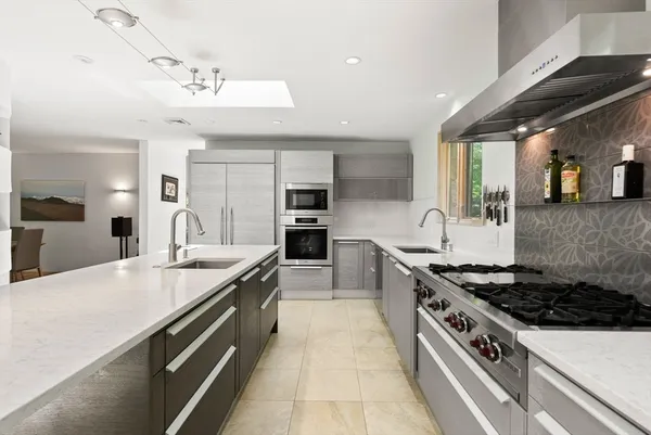 a large kitchen with stainless steel appliances granite countertop a stove and a sink