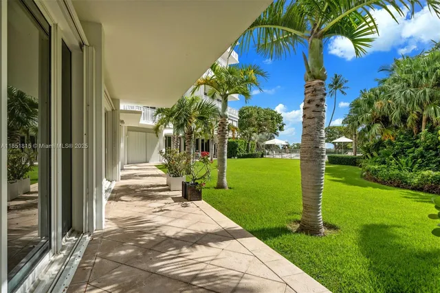 a view of a house with a big yard plants and large trees