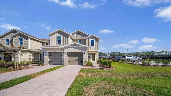a front view of a house with a garden and lake view
