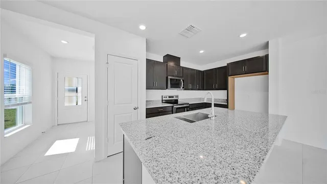 a kitchen with stainless steel appliances granite countertop a refrigerator and a sink