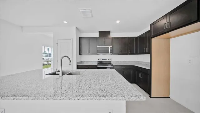 a kitchen with stainless steel appliances granite countertop a sink stove and refrigerator