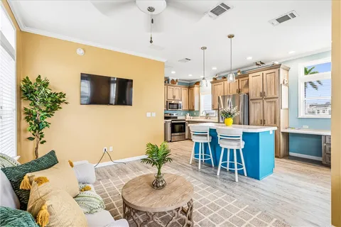a living room with furniture kitchen view and a large window