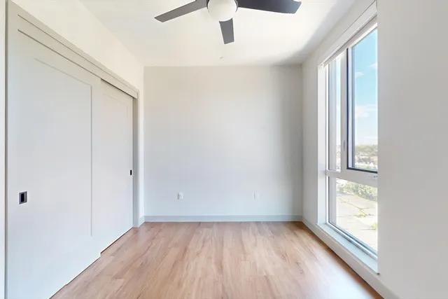 an empty room with wooden floor and windows