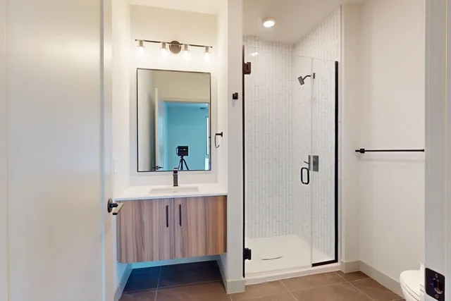 a bathroom with a double vanity sink mirror and shower
