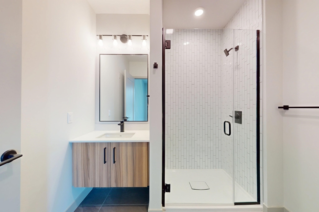 80 Rugg Road, Unit 1311 Boston, MA 02134 - Photo 19 of 20 a bathroom with a shower sink and mirror