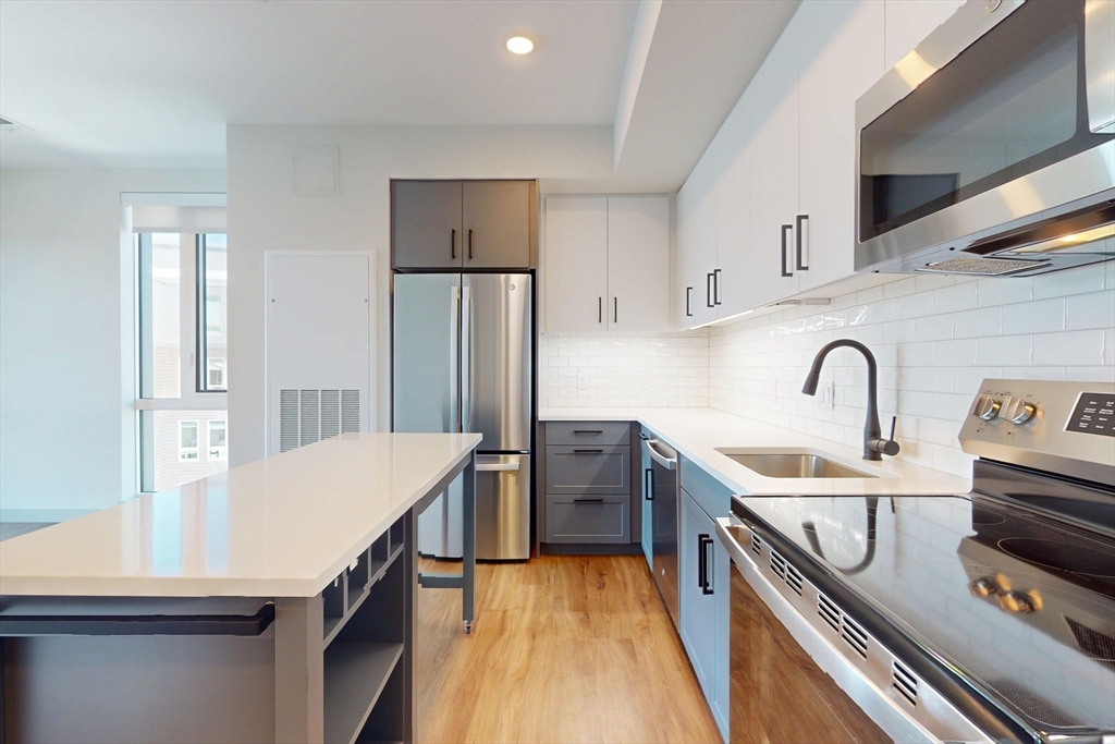 80 Rugg Road, Unit 1311 Boston, MA 02134 - Photo 2 of 20 a kitchen with kitchen island a sink appliances and cabinets
